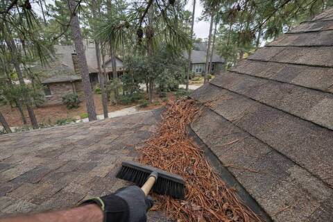 Weathered-wood architectural shingles with pine needles gathered in the valley